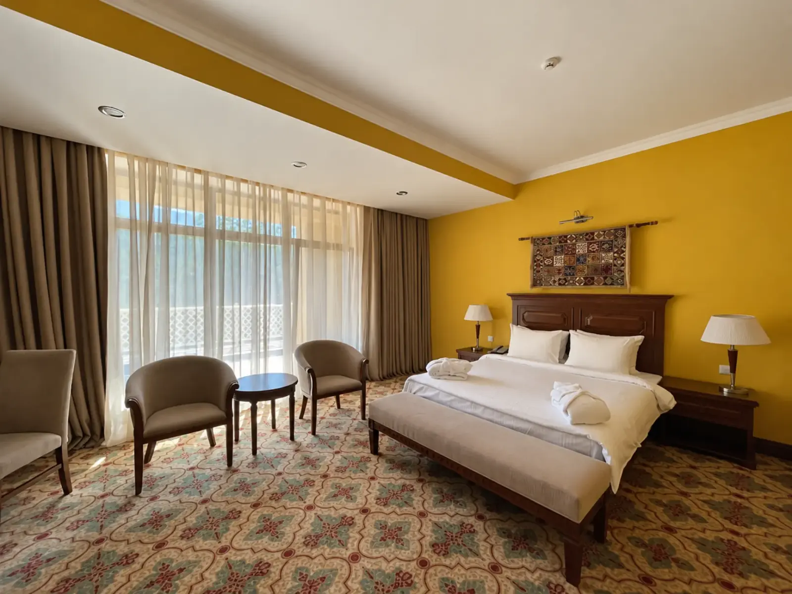 Double bed and seating beside the room window at Samal